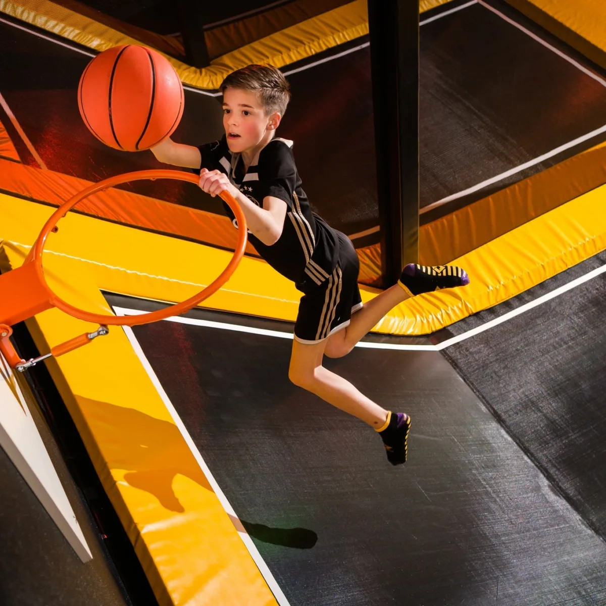 Kind spielt Basketball auf einem Trampolin in der FunZone in Enschede - Uit in Enschede