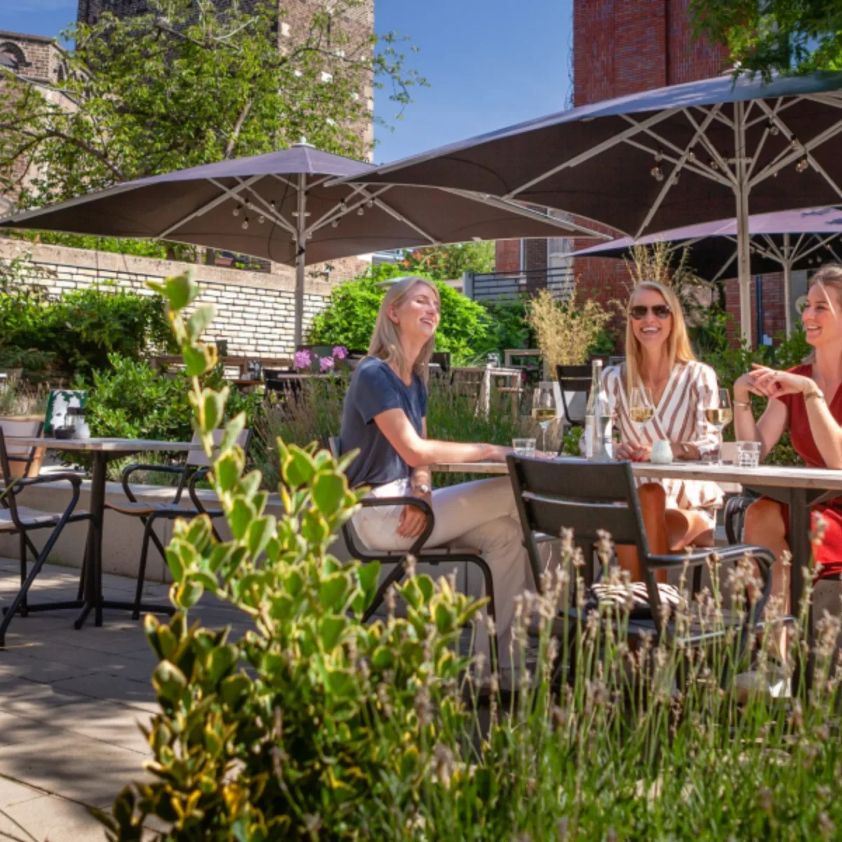 Drie zussen in de binnentuin/theatertuin van restaurant Bardot in Enschede - Uit in Enschede