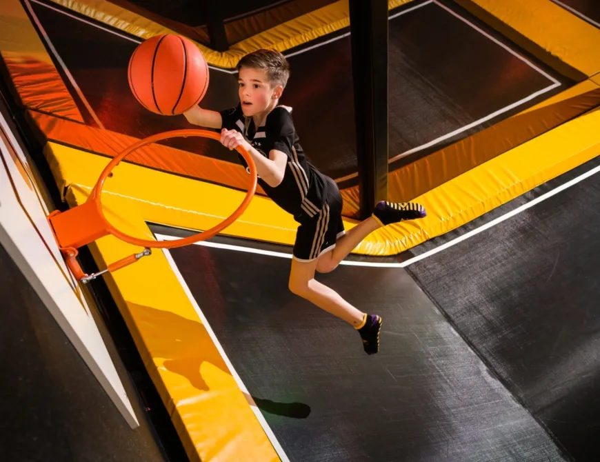 Kind spielt Basketball auf einem Trampolin in der FunZone in Enschede - Uit in Enschede